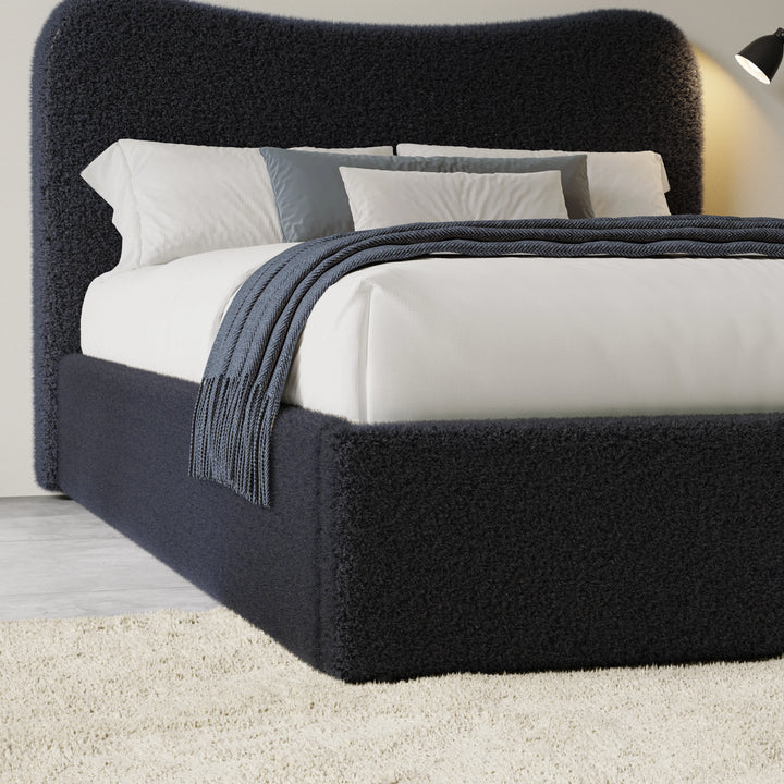 [Double | Blue] Three-quarter view of curved headboard and bedding showing boucle texture with fringed throw draped across