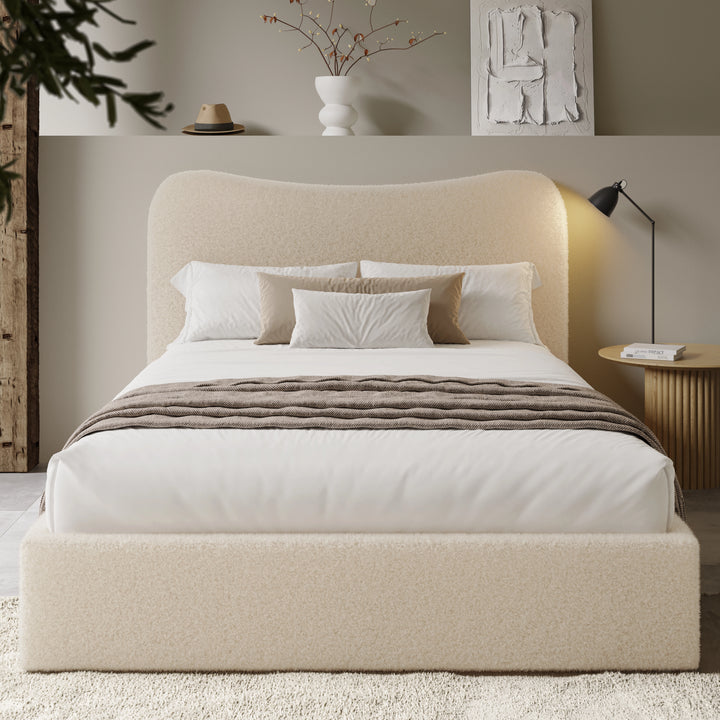 [King | Beige] Boucle bed centred with curved headboard backlit by warm glow beside fluted round side table