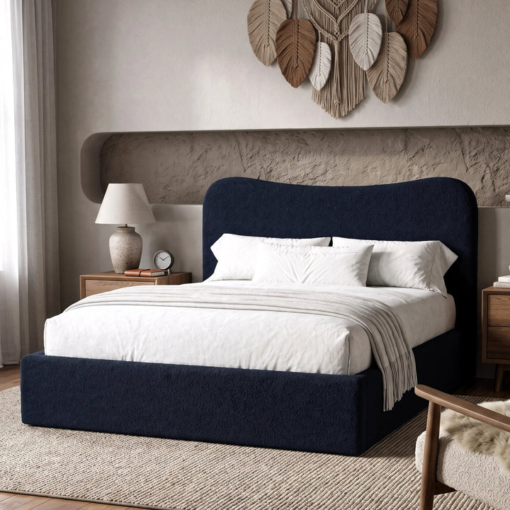 [King | Blue] Boucle fabric ottoman bed from the side with white bedding and fringed throw beside floating shelf with art