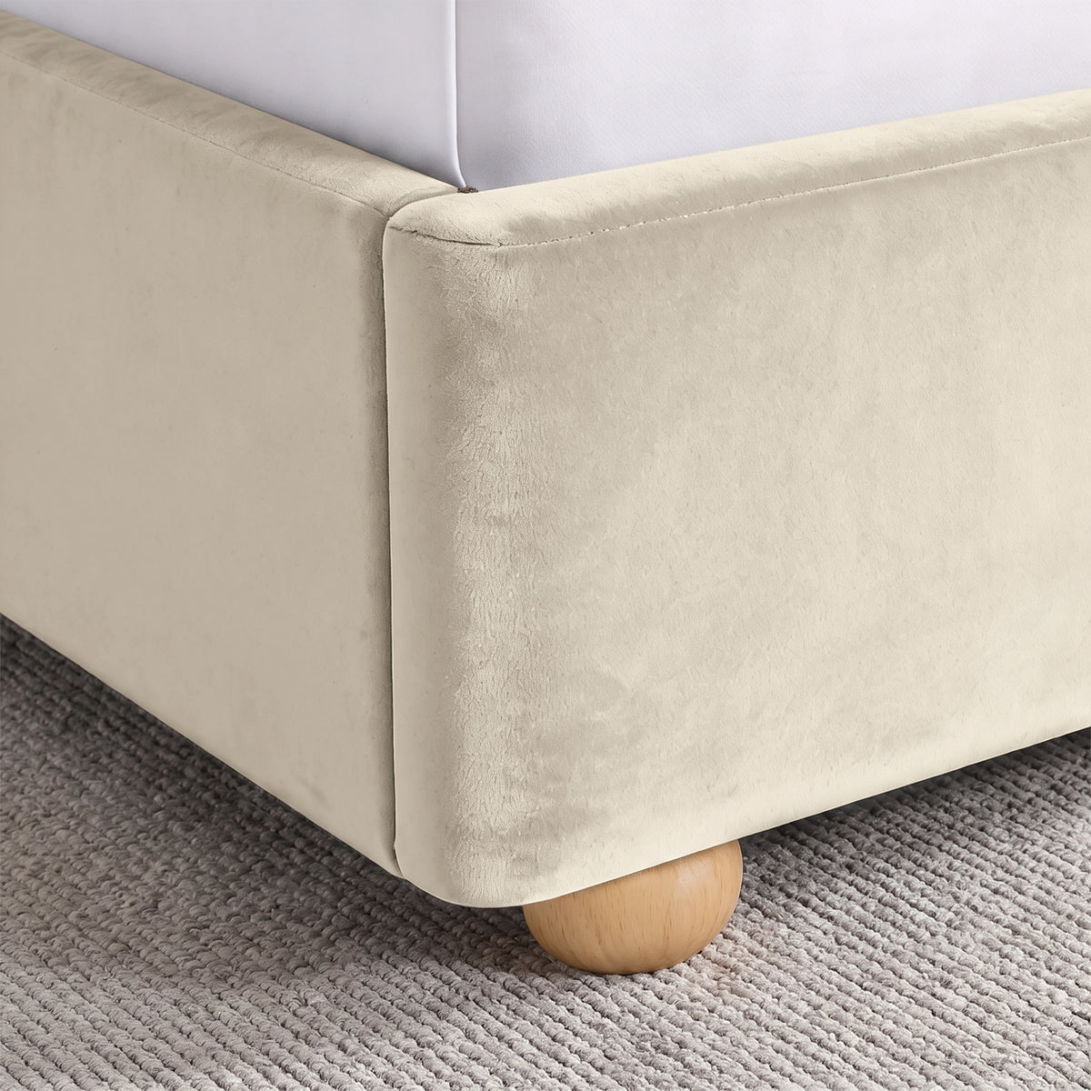 [Beige | King] Close-up of plush upholstered base corner with rounded solid wood foot and soft curved edge