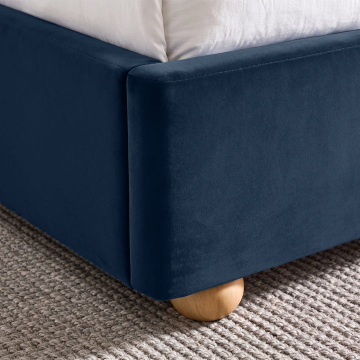 [Blue | King] Close-up of plush upholstered base corner with rounded solid wood foot and soft curved edge