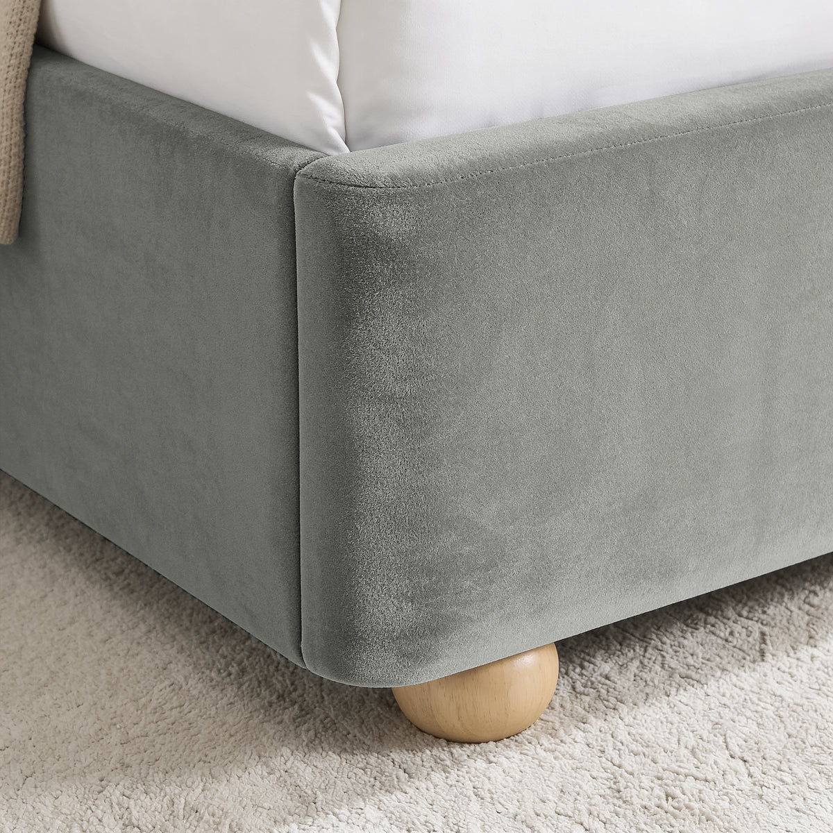 [Light Grey | King] Close-up of plush upholstered base corner with rounded solid wood foot and soft curved edge