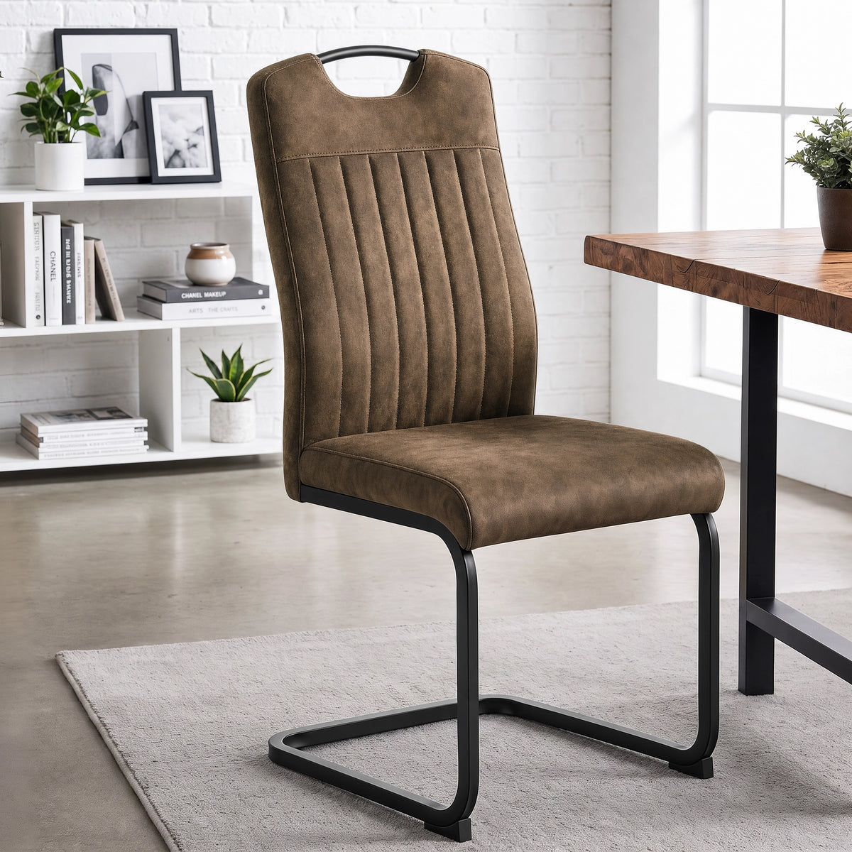 [Dark Brown] High-back dining chair by a wood table with upholstery, carry grip and black loop frame.