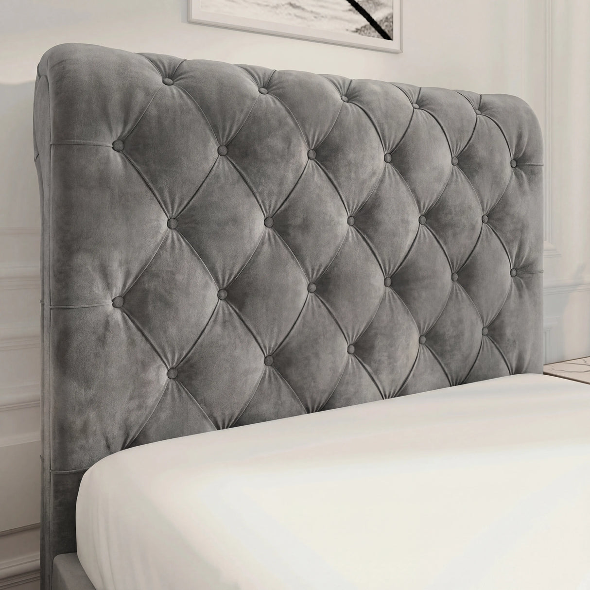 Close view of dark grey upholstered headboard with diamond button tufting and padded finish
