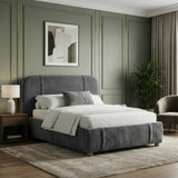 Dark grey upholstered double bed with softly curved headboard in a panelled bedroom setting