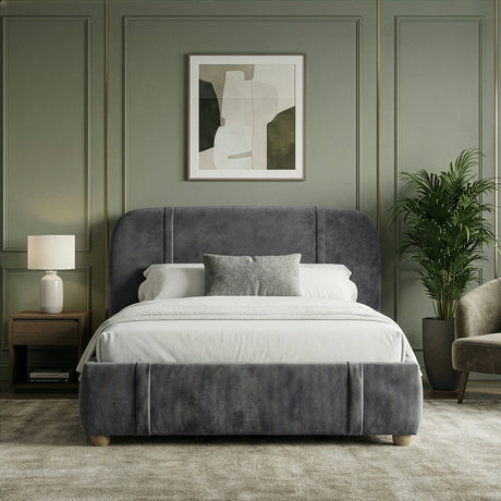Straight-on view of dark grey king bed frame with softly padded backrest and neutral linens