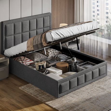 Gray upholstered bed with storage compartment open, revealing various items, in a room with wooden flooring and a window.