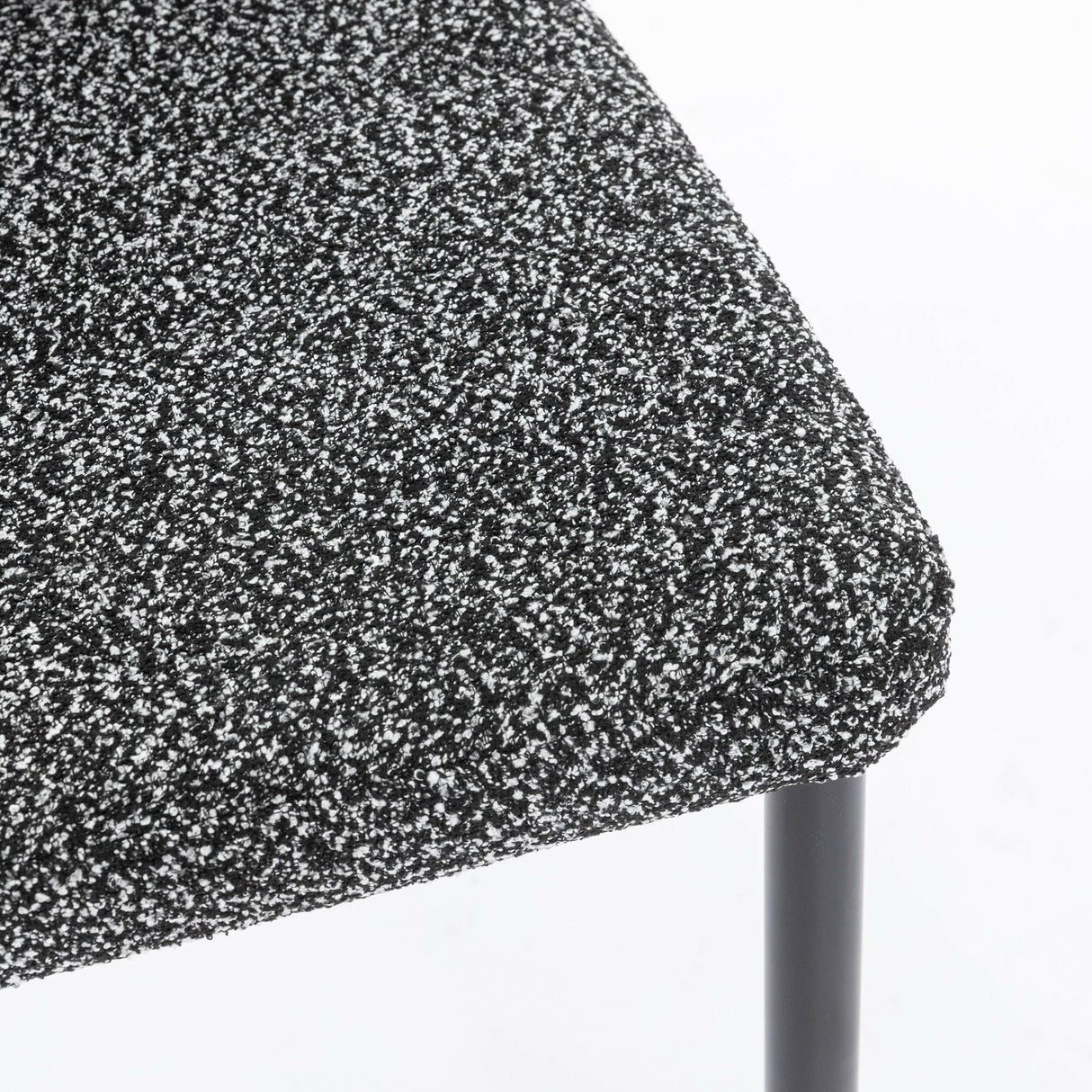 Close-up of dining set chair with black legs and textured grey upholstered seat