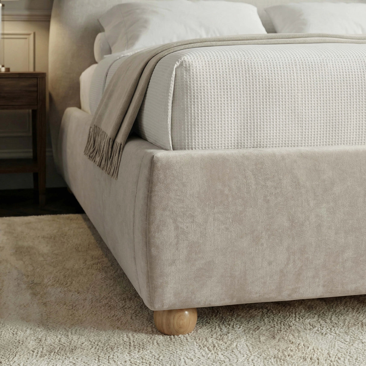 Lower frame detail of the beige double bed frame, showcasing the base and small rounded wooden legs