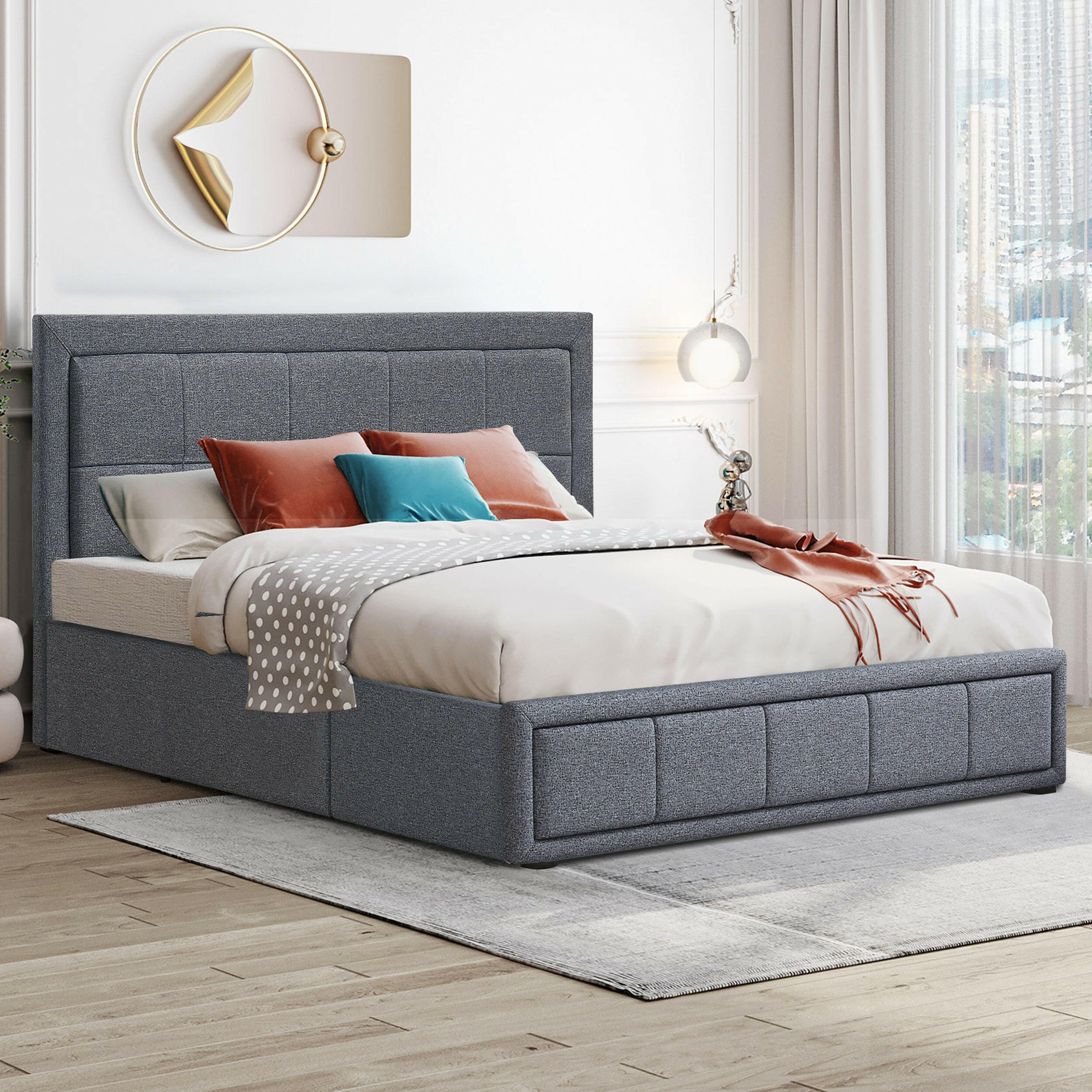 Double bed with storage underneath, featuring a grey upholstered frame and soft bedding with a stylish headboard.