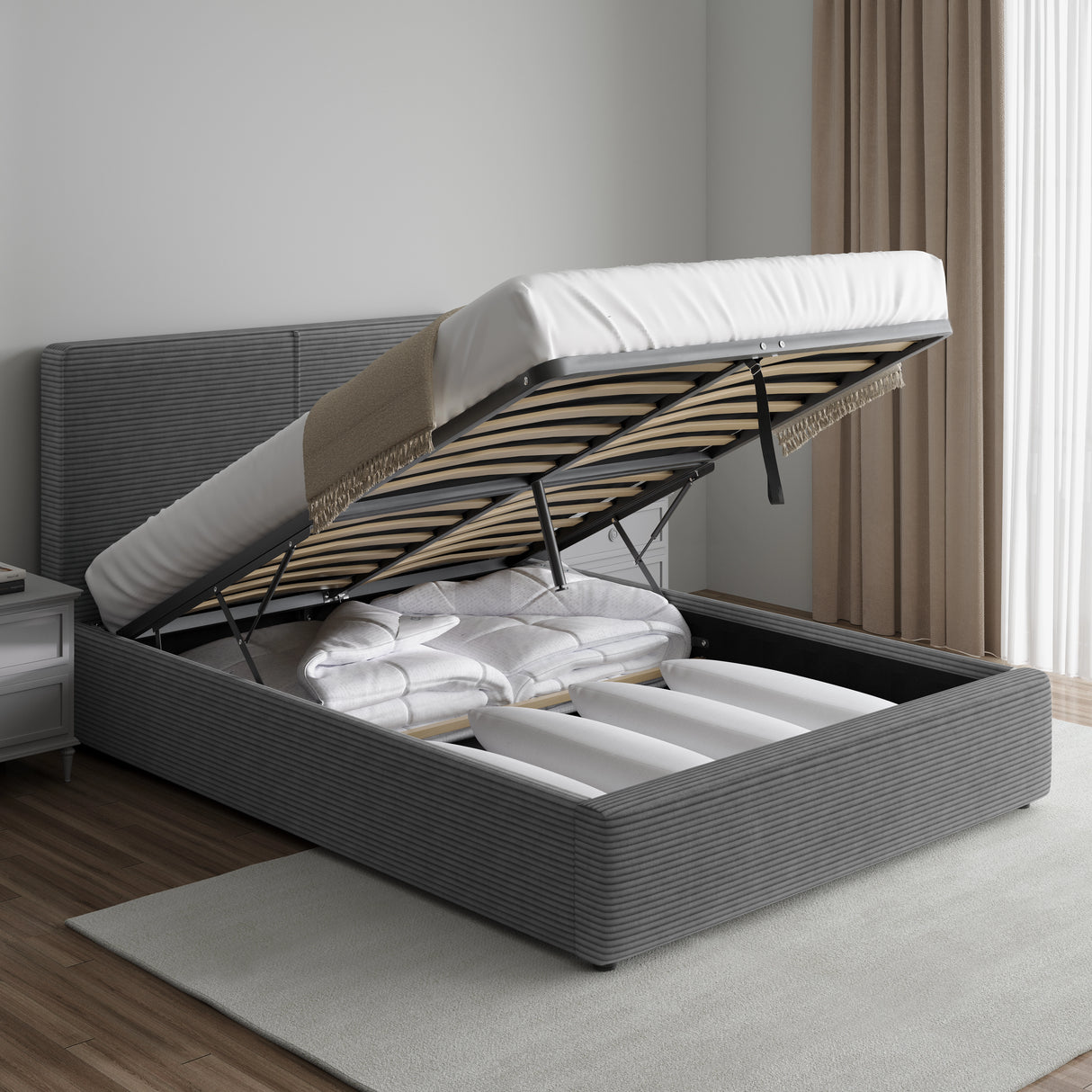 Corduroy ribbed velvet upholstered ottoman bed frame with end lift storage in dark grey, shown with mattress lifted to reveal bedding storage.