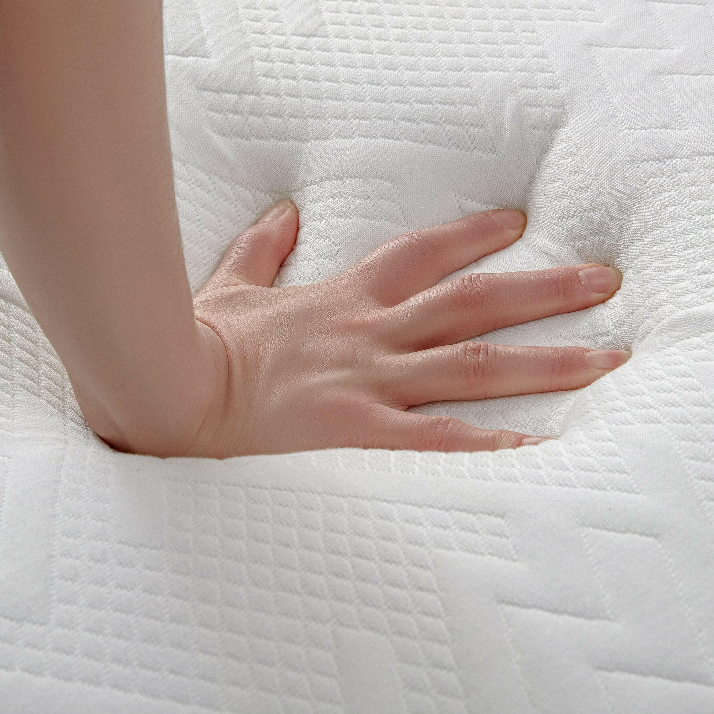 Close-up view of a hand pressing down on a soft, textured memory foam double mattress memory foam.