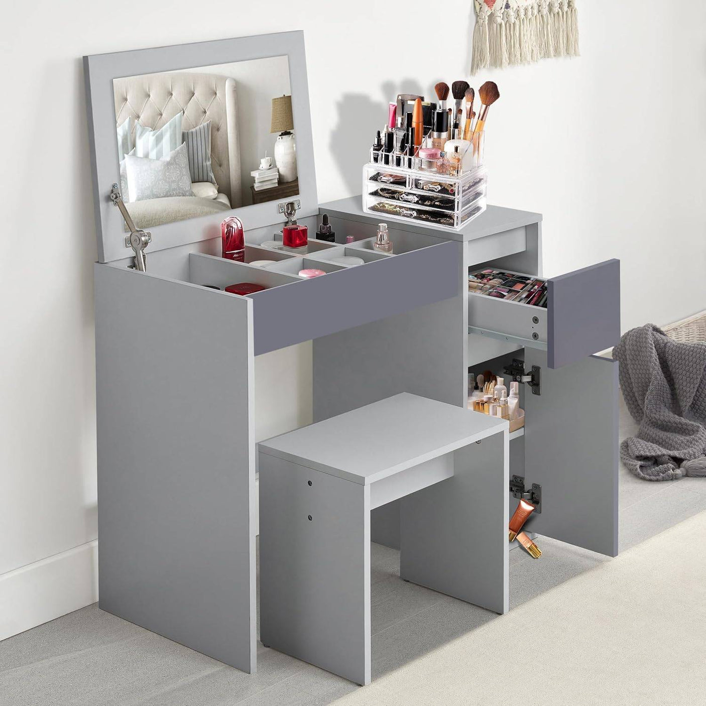 Small dressing table with flip-up mirror and stool in grey, featuring multiple storage compartments and drawers for makeup and beauty accessories.