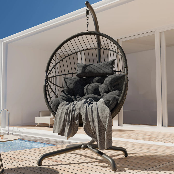 [Black] Outdoor poolside black hanging egg chair on dark stand, black tufted seat and back cushions