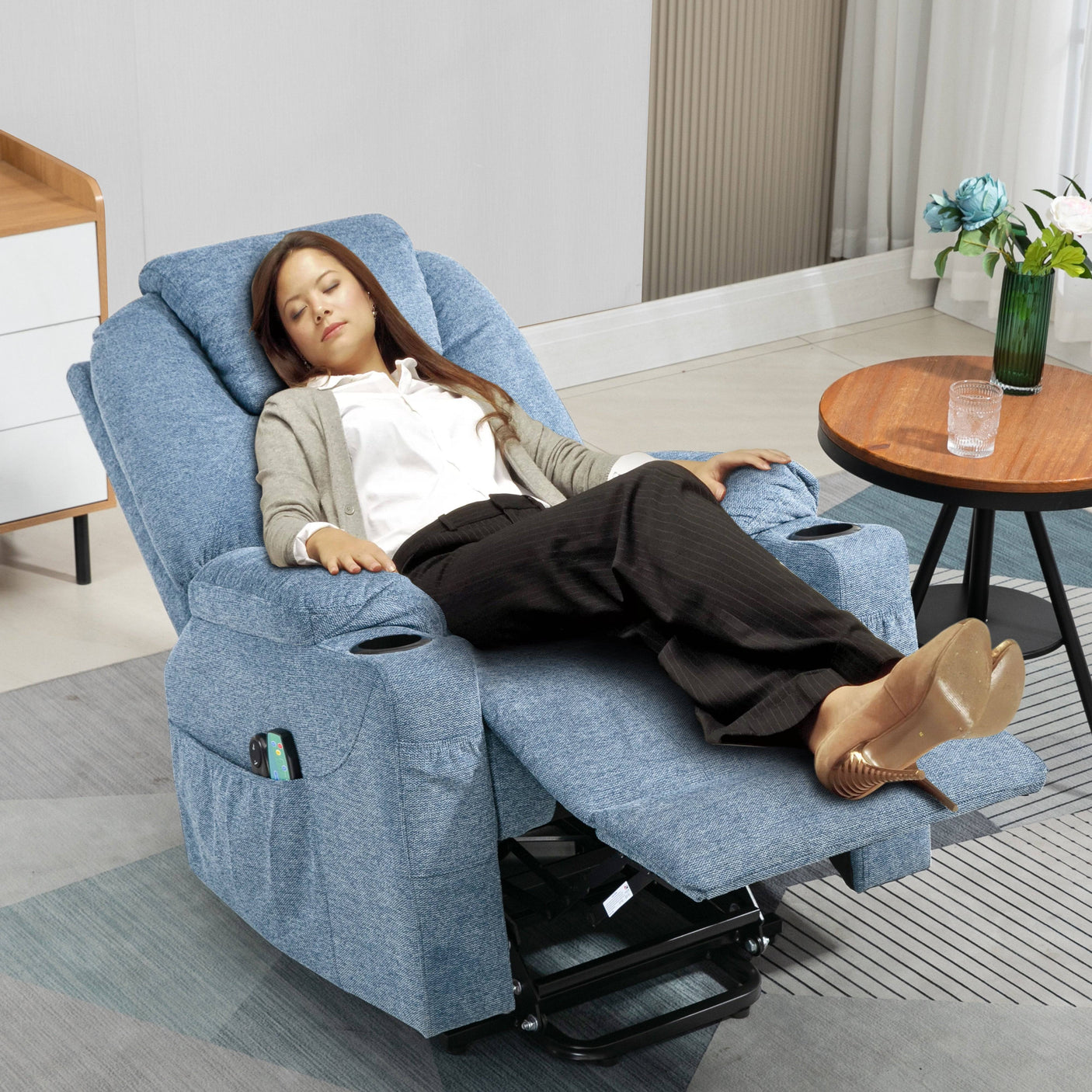 Woman resting on blue electric recliner chair with extended footrest and cup holders, ideal for naps and relaxation.