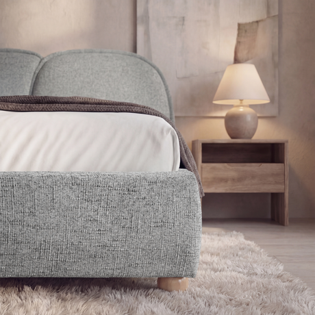 [Double | Grey] Close-up of bed frame corner showing linen fabric texture and short wooden ball foot on shag rug