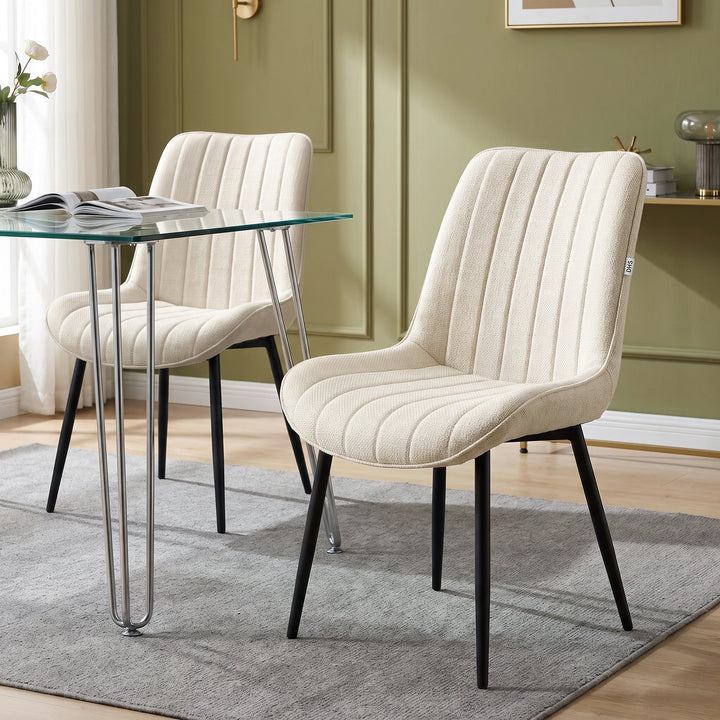[Beige | Set of 2] Fabric dining chair beside a glass table, showing vertical stitching and black metal legs