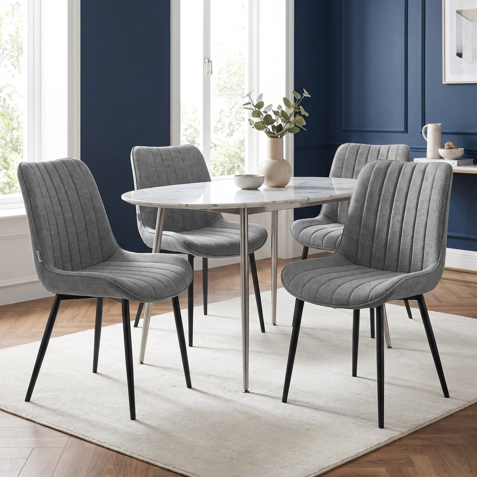 [Grey | Set of 4] Four fabric dining chairs around a round table in a room with a blue feature wall