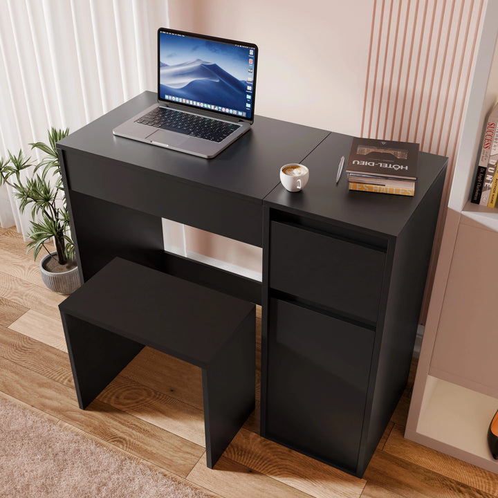 [Black] all-black flip-mirror vanity in desk mode with laptop, two side drawers stacked, and red book