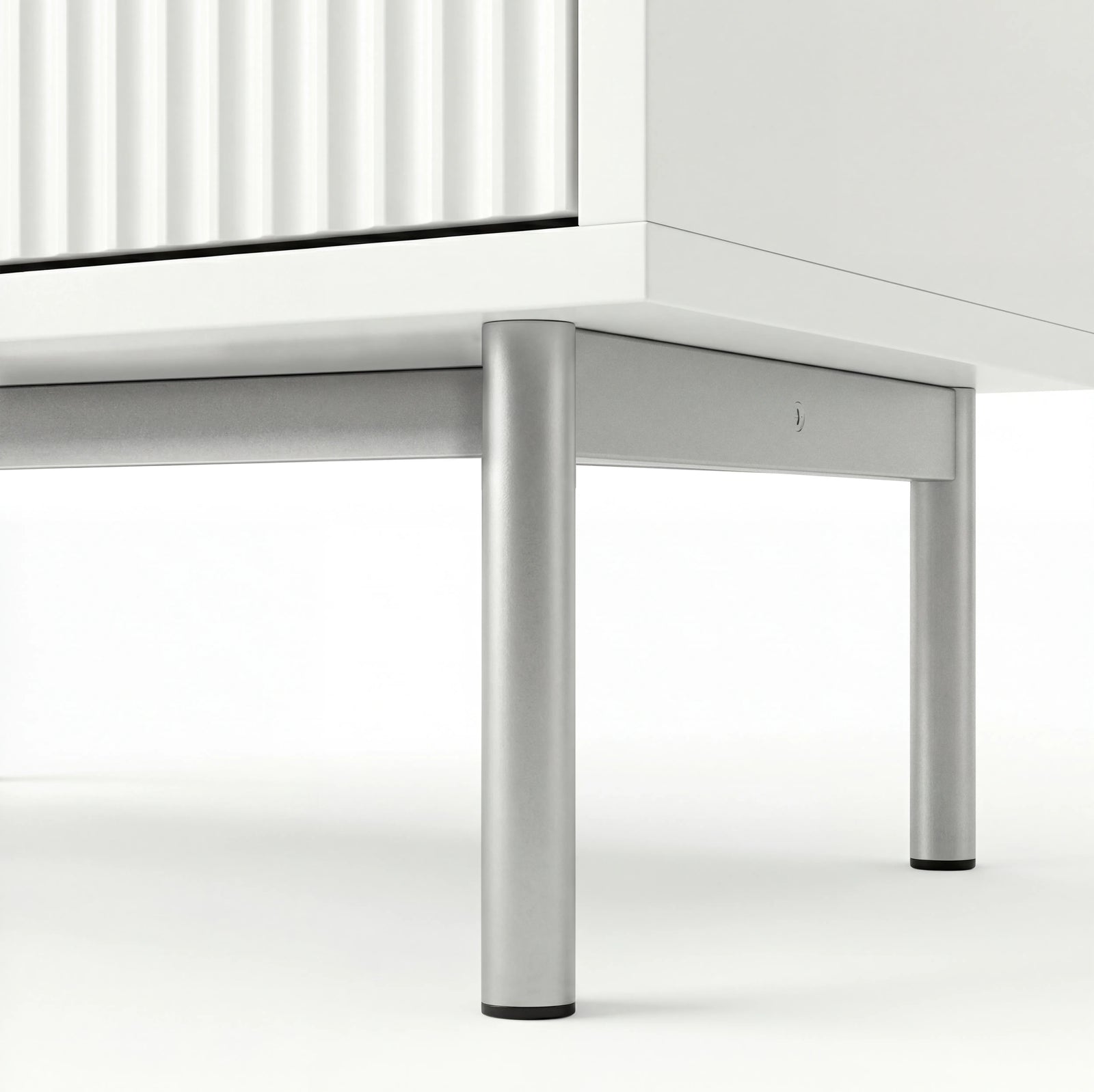 [White] flutrina chest of drawers underside view of the silver metal legs and connecting front frame
