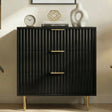 [Black] Flutrina 3 drawer chest with drawer fronts and golden metal legs base placed against a wall