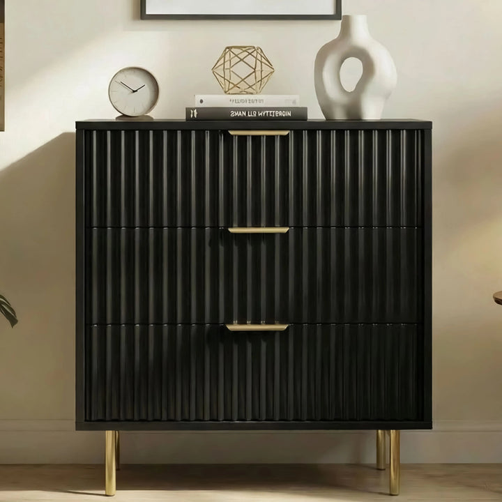 [Black] Flutrina 3 drawer chest with drawer fronts and golden metal legs base placed against a wall