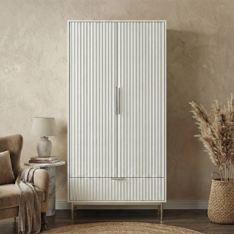 Freestanding white wardrobe with drawer placed in softly lit room with neutral walls and minimal decor