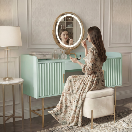 [Sage Green] side-profile lifestyle of the sage green vanity with a person at the lit round mirror and patterned floor