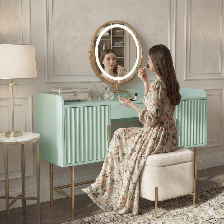 [Sage Green] side-profile lifestyle of the sage green vanity with a person at the lit round mirror and patterned floor