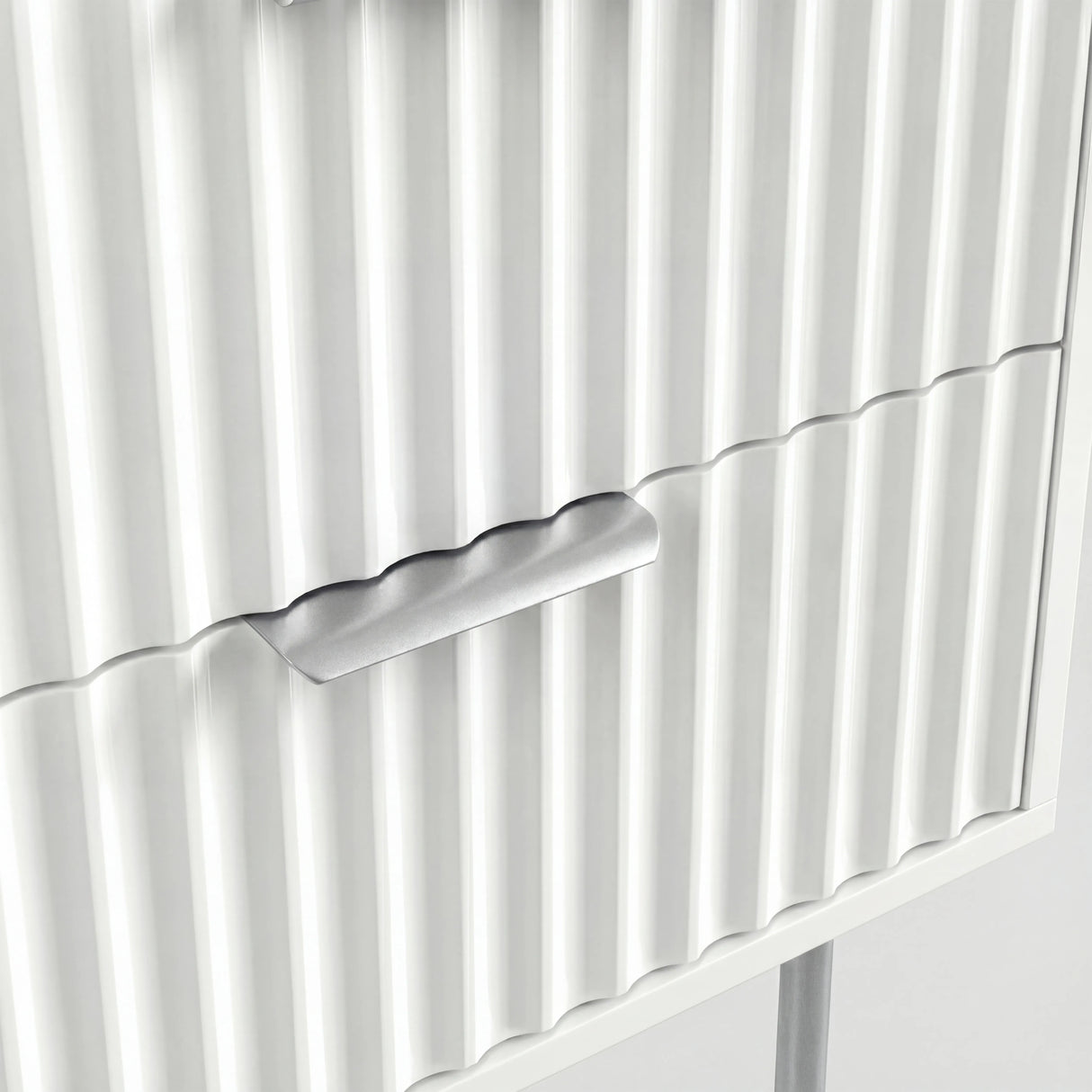 Close detail of silver metal drawer handle and legs mounted on white flutrina cabinet front