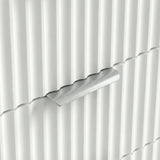 Close view of silver metal handle on white flutrina front of chest of drawers in a natural light 