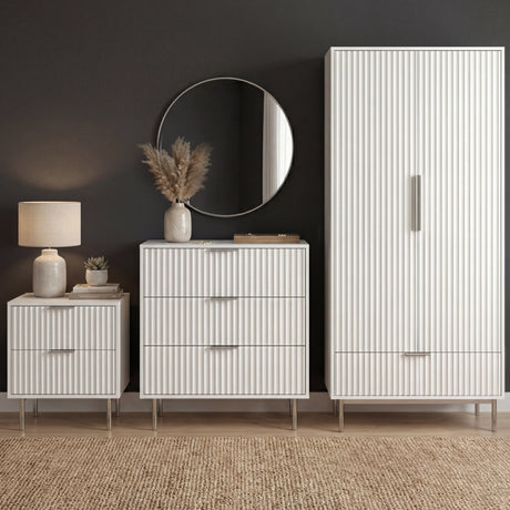 [White] flutrina white wardrobe, chest of 3 drawers and bedside table grouped on a woven rug under a round mirror