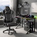 Gaming desk setup with a black and Grey  chair, monitor, and computer components in a room with large windows.