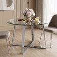 [Clear] Clear glass top and chrome legs dining table styled with two grey chairs, a fruit bowl, flowers and candles on tray.
