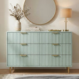 [Sage Green] Lifestyle view of sage green flutrina chest of drawers with gold legs and books styled on top
