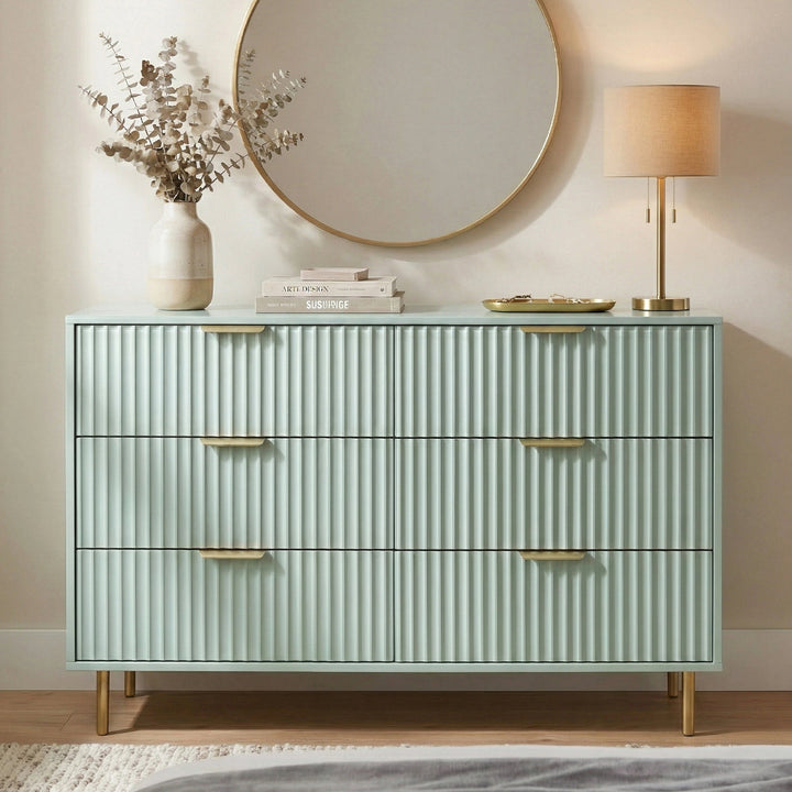 [Sage Green] Lifestyle view of sage green flutrina chest of drawers with gold legs and books styled on top