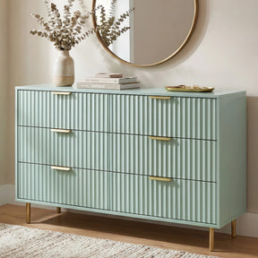 [Sage Green] flutrina 6 drawer chest with metal legs positioned in a contemporary bedroom interior