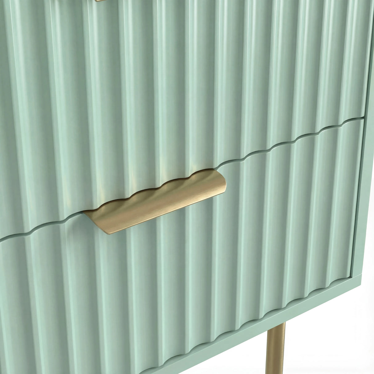 Close detail of the golden metallic handle fixed to the green flutrina design drawer surface of a nightstand