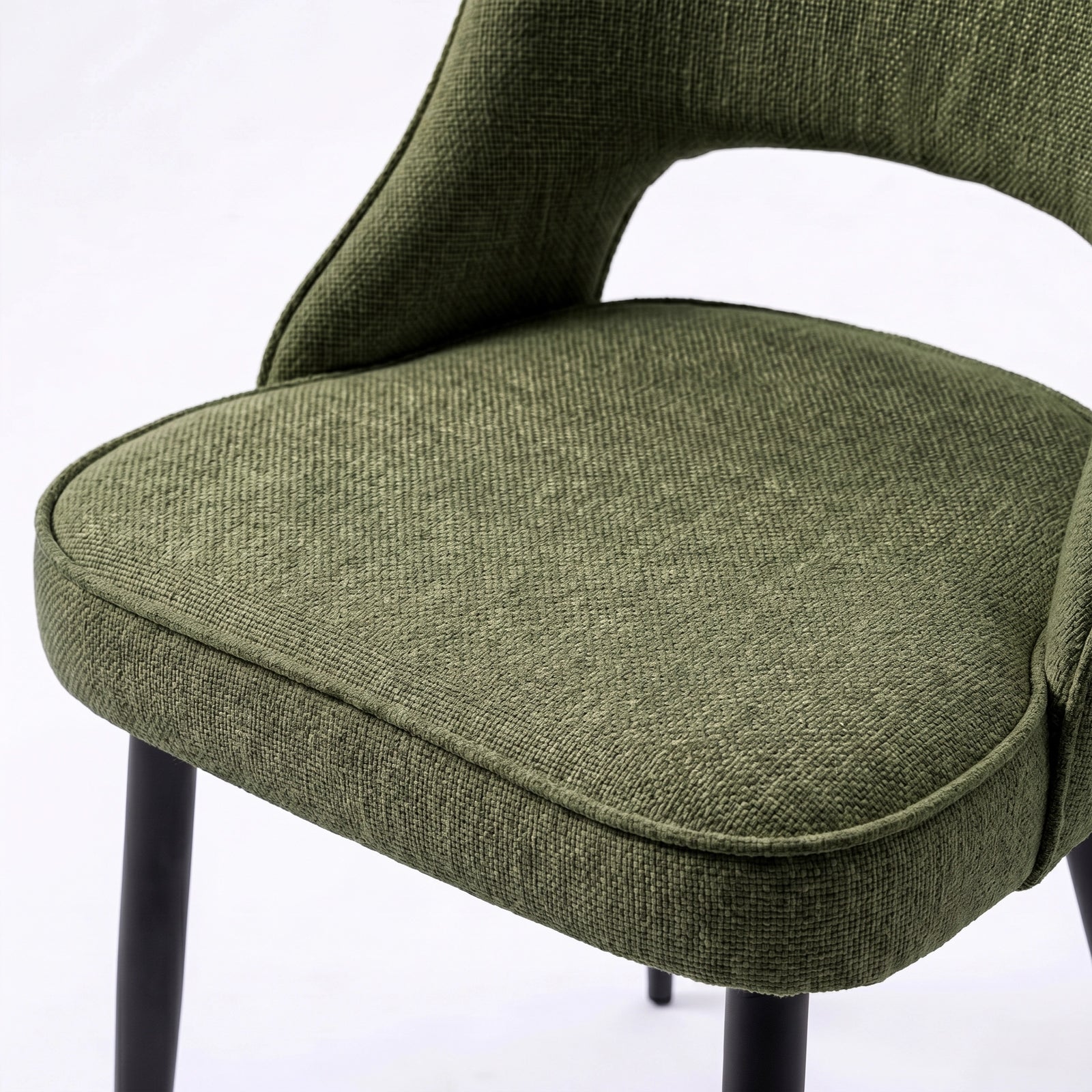 [Set of 4 | Green] Comfy dining chair close-up of padded seat, piped edge, curved open back and black metal legs.