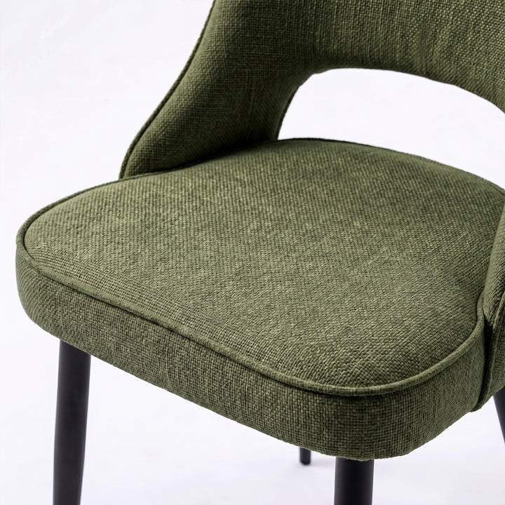 [Set of 4 | Green] Comfy dining chair close-up of padded seat, piped edge, curved open back and black metal legs.