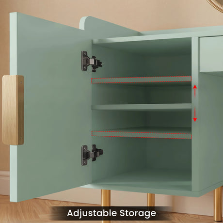 A sage green dressing table with an open door revealing adjustable interior shelves, golden legs, and sturdy steel hinges