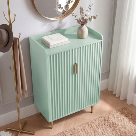 [Green] Flutrina shoe cabinet at an angle showing ribbed door fronts, raised guard panel top, and gold legs on a light wood floor