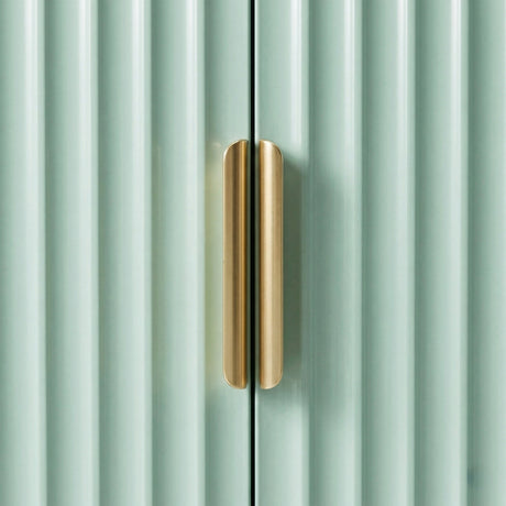 [Green | 60cm] Flutrina close-up of the brushed gold handle sitting between the green fluted door panels in soft light