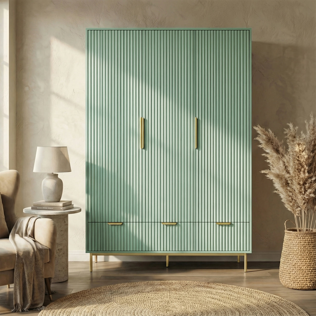 Green three door freestanding wardrobe with gold handles and legs, placed in a natural light room