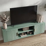 Green TV media unit with vertical textured panels and silver legs, styled for a modern living room centerpiece.