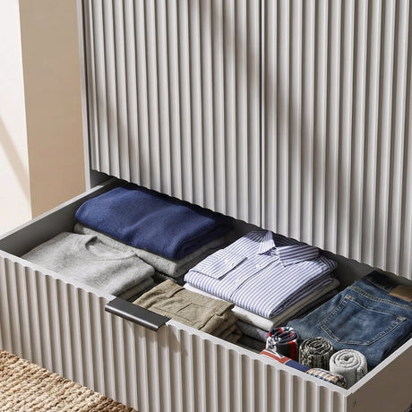 [Grey] wardrobe drawer storage section with organised folded garments inside and black metal sleek handles