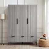 Grey flutrina design triple wardrobe with drawers and black handles placed against a wall in a bedroom