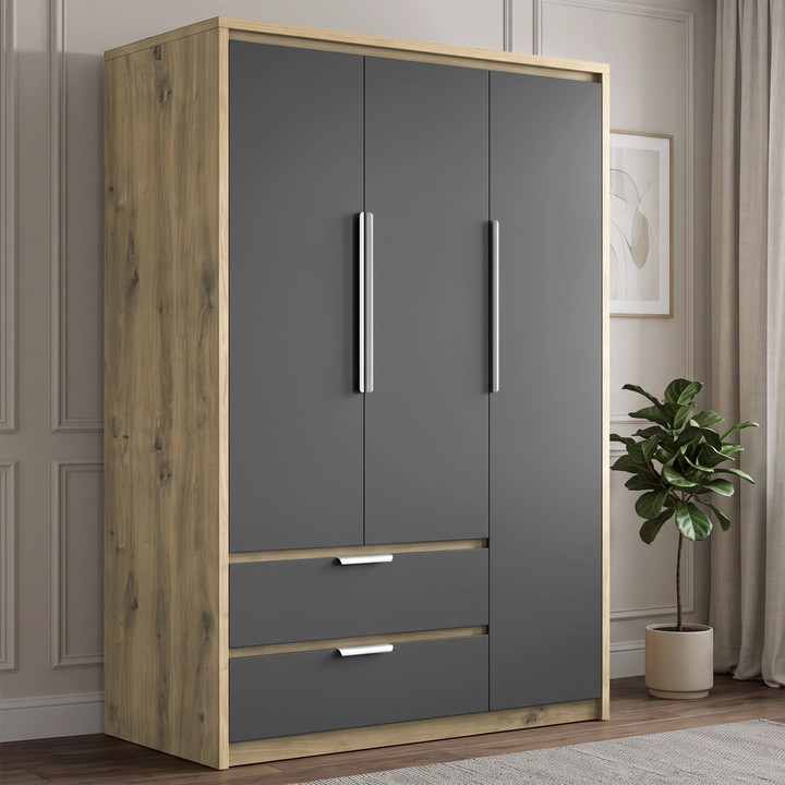 [Grey] A tall three-door wardrobe with  grey doors, silver handles, and two lower drawers with silver pulls, set in a styled room with a wood-look frame, a potted plant, and neutral paneled walls.