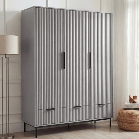 Grey three door wardrobe with drawers styled in modern room with neutral walls and decor
