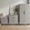 Matching grey furniture set containing a wardrobe, drawers for the bedroom, and a bedside table in a natural light room